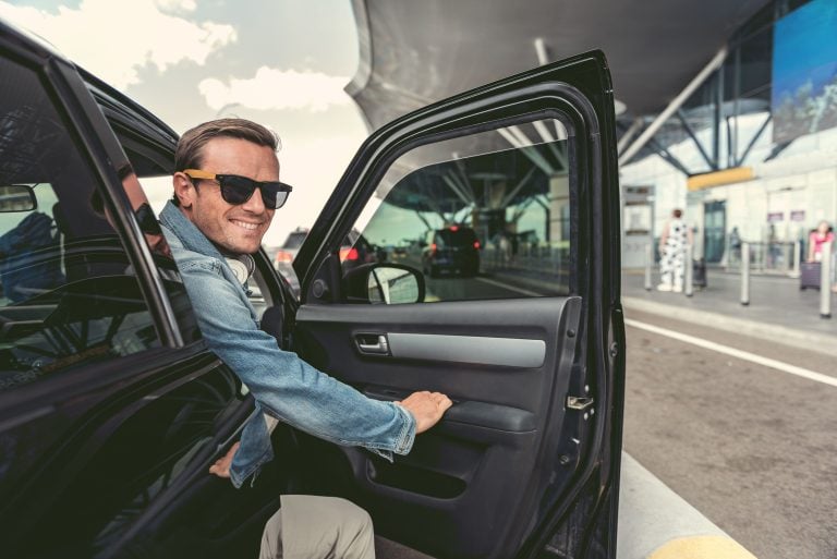 positiver Mann sitzt im Auto